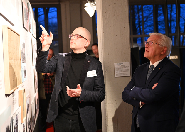 Zwei Männer stehen vor einem Exponat der Ausstellung.