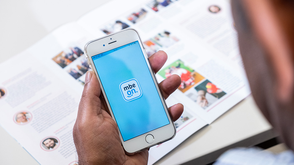 Auf einem Smartphone wird die Startseite der mbe-on - App gezeigt (Quelle: BAMF / Bildkraftwerk) Auf einem Smartphone wird die Startseite der mbe-on - App gezeigt