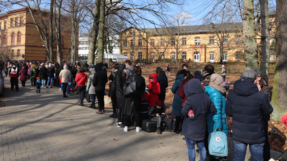 Geflüchtete Menschen aus der Ukraine stehen vor einem Gebäude (Quelle: BAMF) Geflüchtete Menschen aus der Ukraine stehen vor einem Gebäude