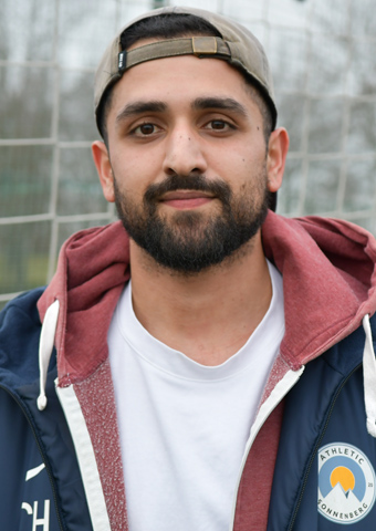 Ein junger Mann mit Kappe und Sportkleidung (Quelle: © BAMF | Kristin Kasten) Ein junger Mann mit Kappe und Sportkleidung