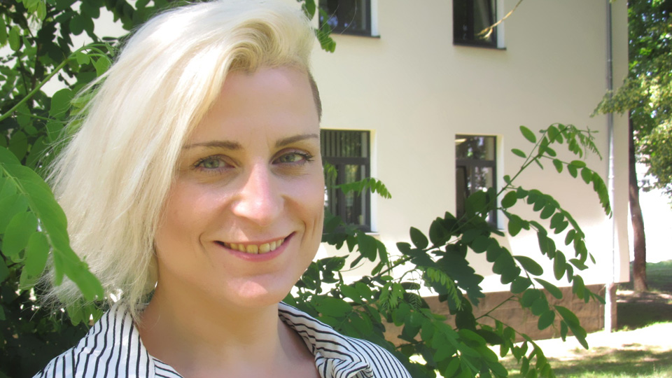 Eine Frau lächelt in die Kamera (Quelle: BAMF) Eine Frau lächelt in die Kamera