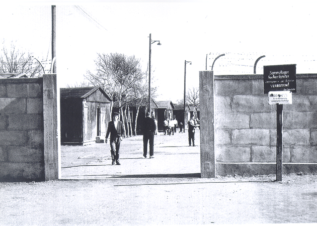 Mehrere Personen laufen auf einem Weg hinter einer Zufahrt. (Quelle: BAMF) Mehrere Personen laufen auf einem Weg hinter einer Zufahrt.