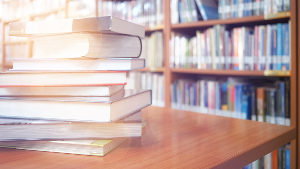 Bild von einem Bücherstapel auf einem Tisch (Quelle: © AdobeStock | ชนิตสิริกานติ์ ณเชียงใหม่/EyeEm) Bild von einem Bücherstapel auf einem Tisch