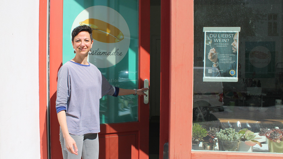 Eine Frau steht vor der Eingangstür eines Geschäftes. (Quelle: BAMF | Gerd Fürstenberger) Eine Frau steht vor der Eingangstür eines Geschäftes.