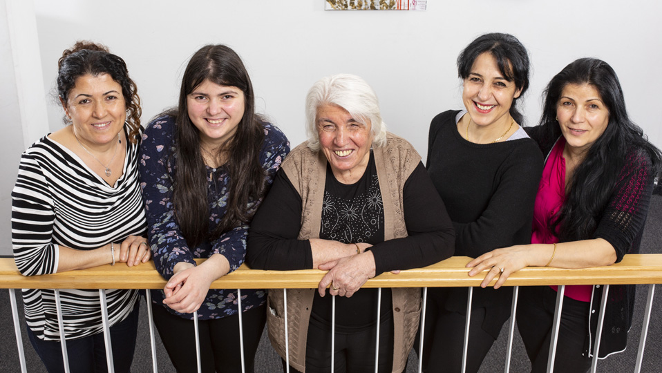Fünf Frauen stehen an einem Geländer