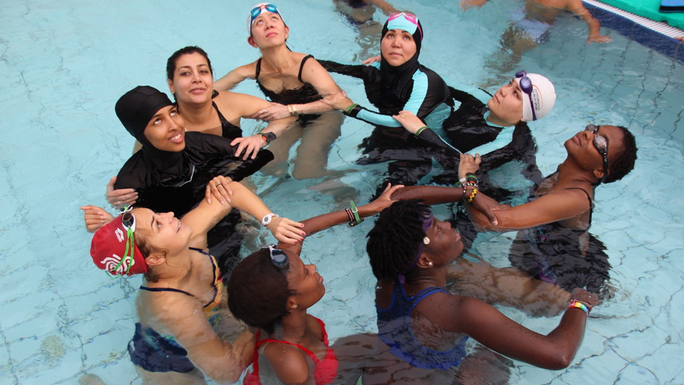 Eine Gruppe von Frauen bilden in einem Schwimmbecken einen Kreis