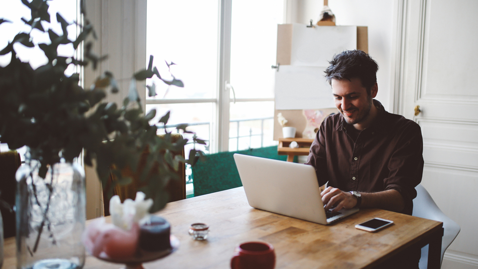 Ein Mann sitzt vor einem Laptop an einem Tisch (Quelle: © iStock|lechatnoir) Ein Mann sitzt vor einem Laptop an einem Tisch