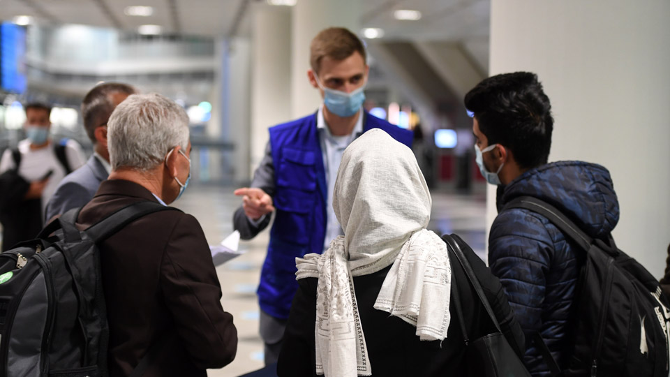 Fünf Personen mit Maske stehen im Kreis und unterhalten sich.  (Quelle: BAMF | Peter Roggenthin) Fünf Personen mit Maske stehen im Kreis und unterhalten sich.