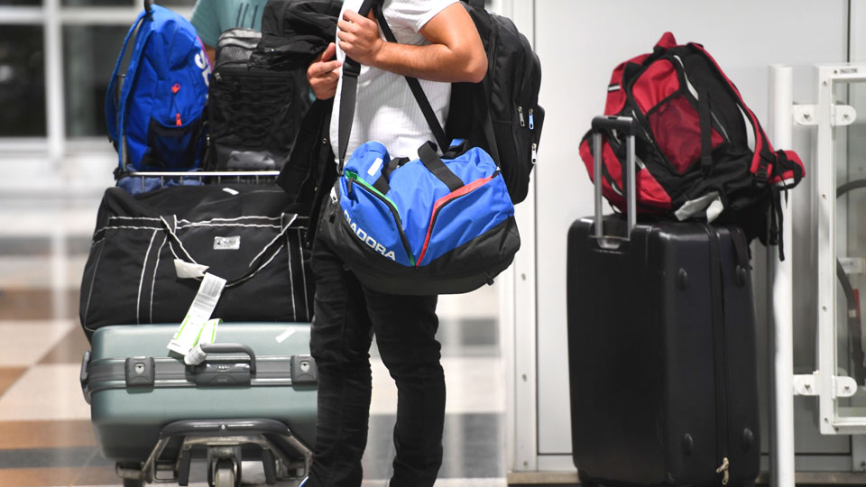 Eine Person trägt eine Tasche und ist umgeben von Gepäckstücken. (Quelle: BAMF | Peter Roggenthin) Eine Person trägt eine Tasche und ist umgeben von Gepäckstücken.